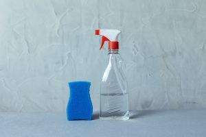 Butelka ze spryskiwaczem i niebieska gąbka – chemia gospodarcza na co dzień