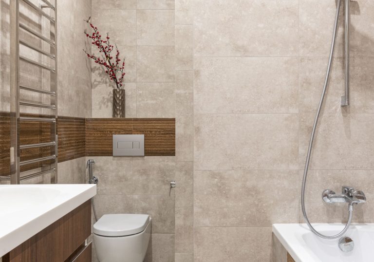 Nowoczesna łazienka z płytkami i białą toaletą – kostka, zawieszka czy żel do WC
