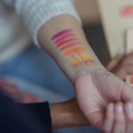 Próbki kolorowych kosmetyków na przedramieniu – dobór koloru korektora
